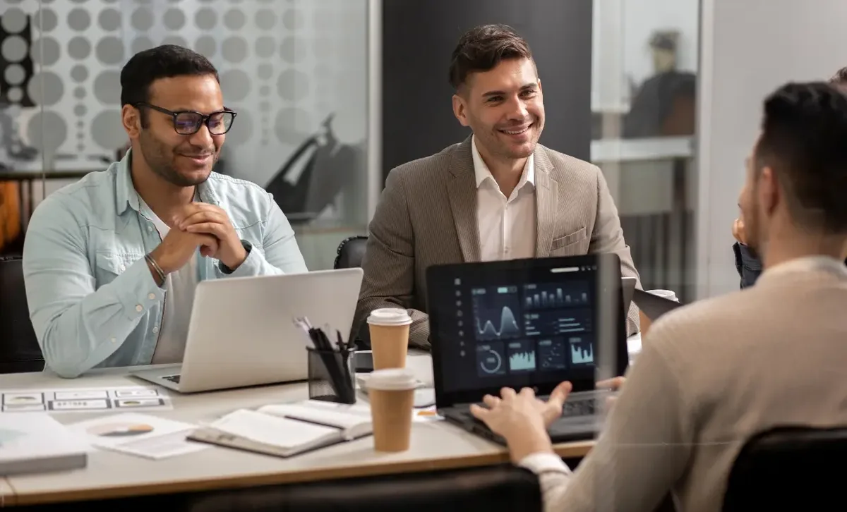 Two founders reviewing figures on a laptop in a small office